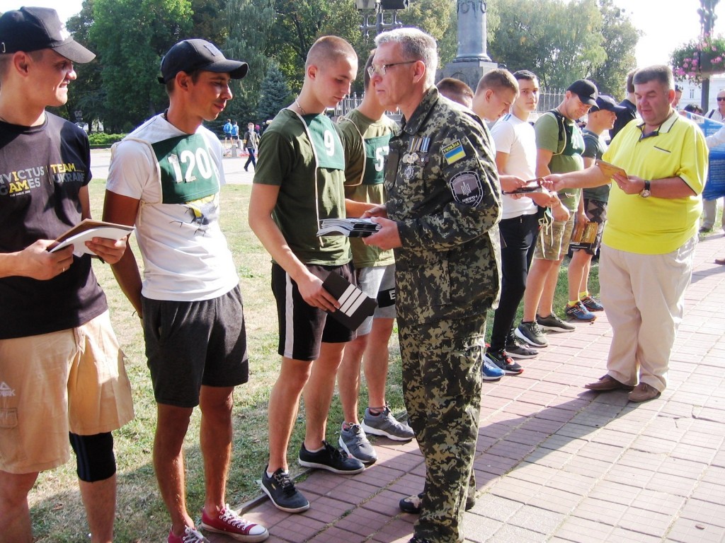 Руслан Рогов і Олександр Товпига вручають учасникам пробігу брошуру Мазепинці-петлюрівці-Бандерівці
