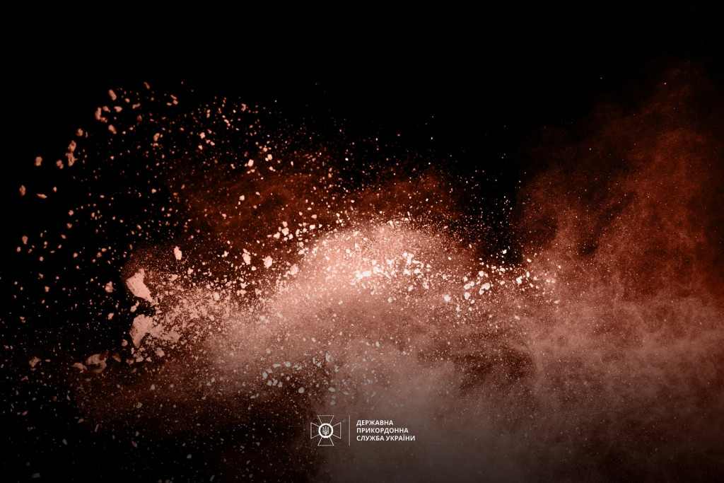Golden powder explosion on black background. Freeze motion.