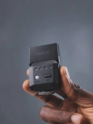 Задня панель спалаху Ulanzi F12 Mini Speedlite з індикаторами потужності в руці