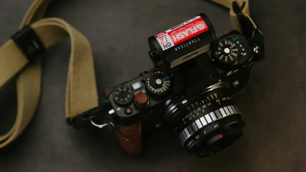 Мануальний спалах TTArtisan M01 у формі фотоплівки на чорній камері Nikon